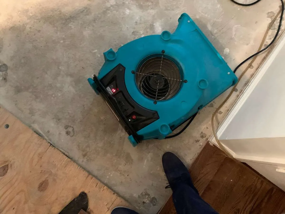 Air mover drying subfloor during Commercial Water Damage Restoration in New Ipswich
